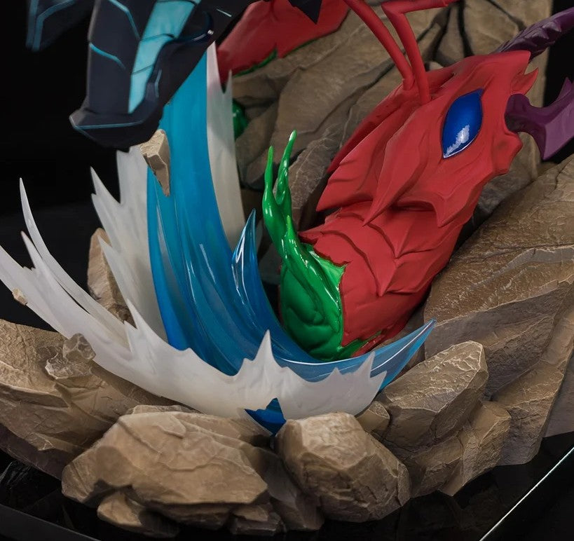 A close-up of a red dragon figurine or collectible statue emerging from cracked brown rocks, with blue and white water-like splashes, green accents, and a dark upper body visible in the background.