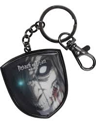 An Attack on Titan keychain featuring a shield-shaped charm with a black and white illustration of the Titan Levi, attached to a black metal split ring and swivel clasp on a white background.