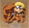 An anime collectible figure of Naruto with his Nine-Tailed Fox on a clear acrylic stand, set against a plain brown background.