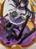 Figurine of a character with long black hair and a white outfit, holding weapons on a purple and gold background.