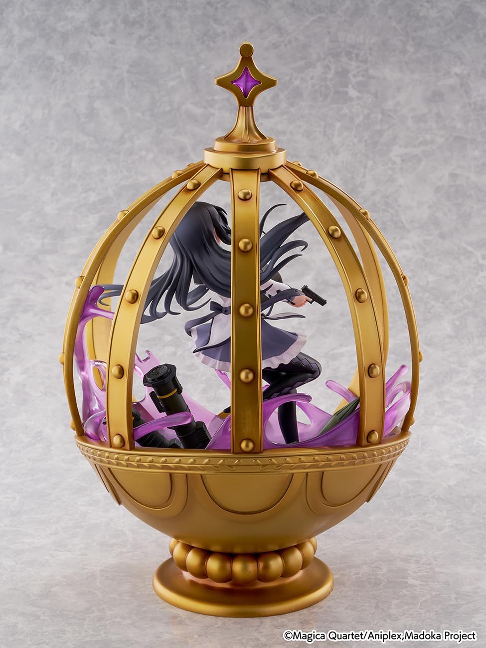 Decorative item with a character inside a gold and purple ornate case on a gray background