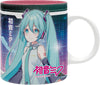A white ceramic mug featuring a colorful graphic print of Hatsune Miku with her signature turquoise twin-tails, headphones, and Japanese text on a dark blue and purple digital background.