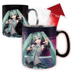 A black ceramic mug featuring an anime-style character with long teal pigtails and a gray-and-teal outfit, shown in two views on a white background. One view shows the mug fully colored, and the other shows a red arrow with °C/F text indicating a color-changing temperature effect.
