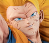Close-up of an anime collectible figure showing a character with bright yellow hair, blue eyes, and a blue outfit against a matching yellow background.