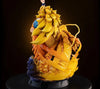 A highly detailed collectible statue of a dragon-like creature with long flowing yellow hair, orange and gold scales, and a small character figure on top, displayed on a black pedestal against a dark background.