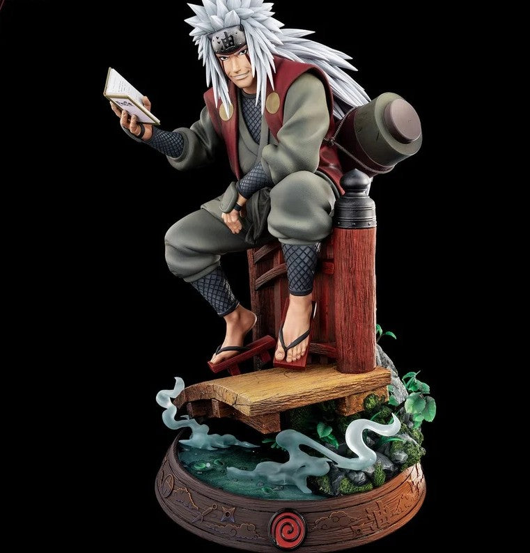 A detailed collectible figurine of the anime character Jiraiya from Naruto, depicted sitting on a wooden platform and holding a book. The figure is set against a solid black background.