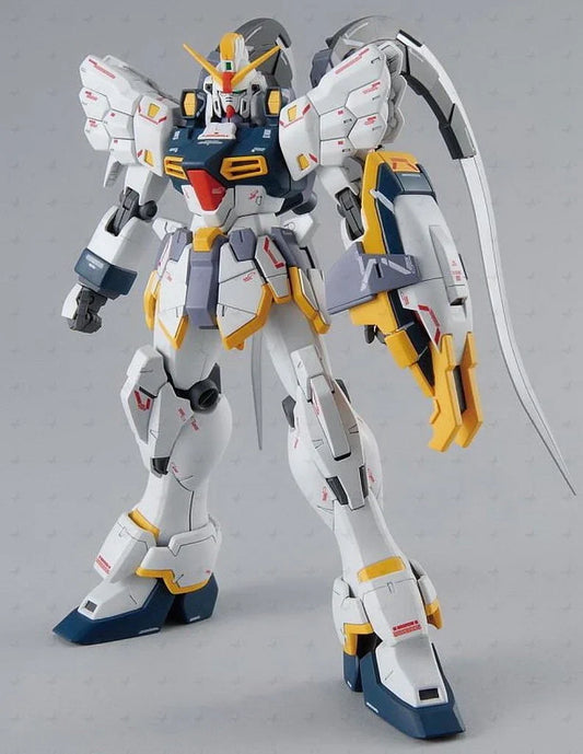 A detailed Gundam action figure or model robot in a white, gray, and yellow color scheme, standing on a light gray background and holding a curved sword.