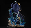 A detailed anime action figure of a character in a dynamic pose, wearing a dark blue cloak and black outfit, holding a large silver sword, set on a rocky base with blue energy effects against a black background.