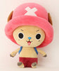 Plush toy with a pink hat and red pants on a light pink background