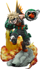 A collectible action figure of Katsuya Bakugo from My Hero Academia, posed dynamically on a rocky base with orange and yellow flames and a green and silver hero gauntlet.